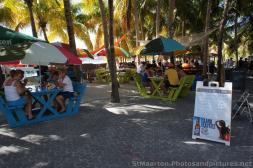 Tourists eating and drinking next to shady palm trees in Philipsburg St Maarten.jpg
