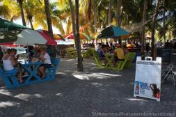 Tourists eating and drinking next to shady palm trees in Philipsburg St Maarten.jpg