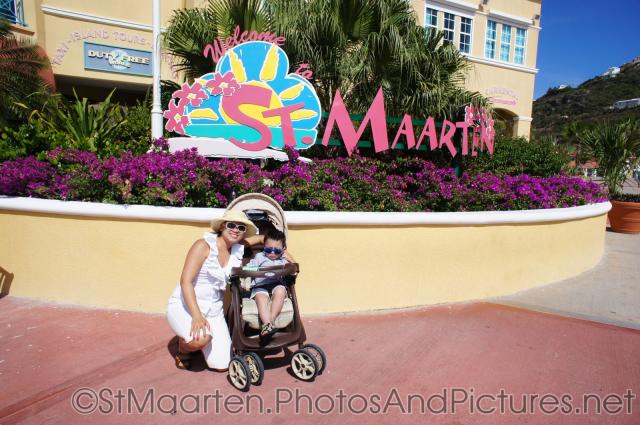 Darwin in a stroller next to mommy under Welcome to St Maarten sign.jpg
