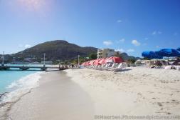 Beach chairs and umbrellas and hills in the distance as viewed from beach of Philipsburg St Maarten.jpg